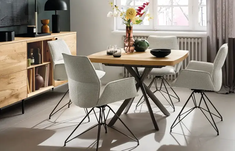 Moderner Essplatz mit quadratischem Holztisch, hell gepolsterten Stühlen und Sideboard aus Holz – perfekte Einrichtungsidee für kleine Essbereiche mit Stil und Komfort.